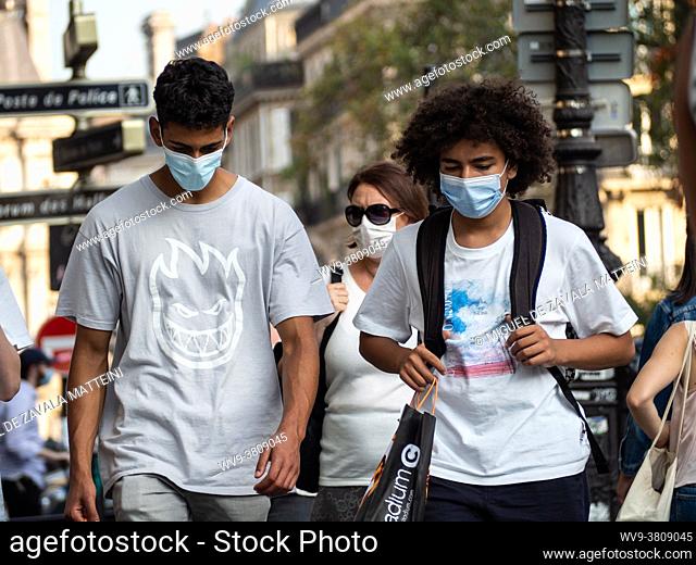 Young people walk down the street with their face mask