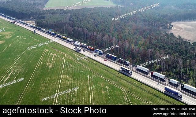 18 March 2020, Brandenburg, Frankfurt (Oder): Trucks jam on the Autobahn 12 about 10 kilometers before the German-Polish border crossing (aerial photo with a...