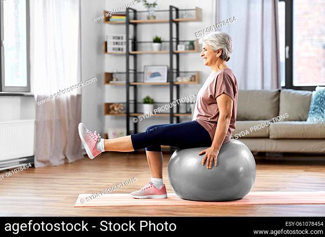 senior woman training with exercise ball at home