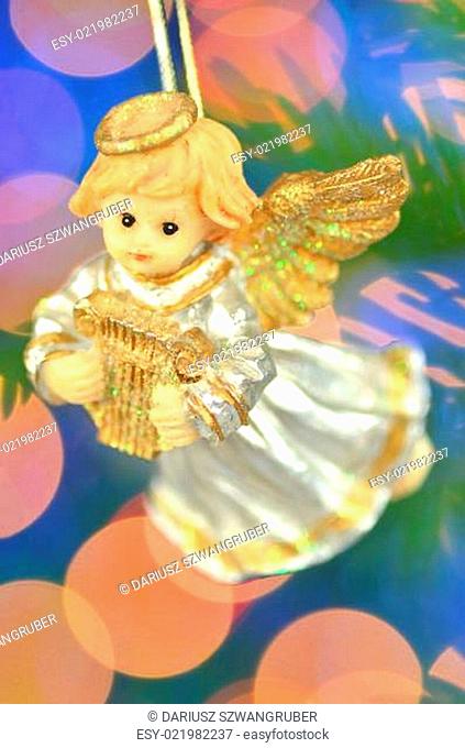 christmas decoration, figure of little angel playing the harp against bokeh background