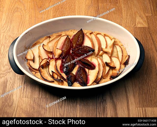 Cake with plum and apples in a baking dish, homemade, healthy food, organic food