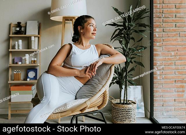 Woman contemplating while sitting on chair at health club