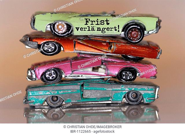 Broken miniature cars with lettering Frist verlaengert!, German for deadline extended, extension of the environmental bonus for the trading in of old cars when...