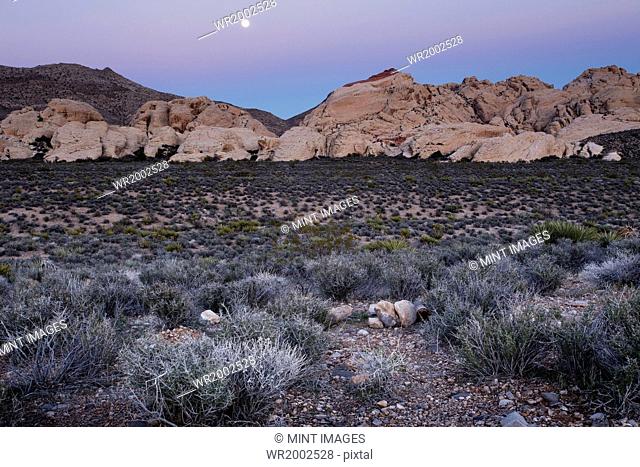 The moon rising over the mountains in Red Rock Canyon in Nevada
