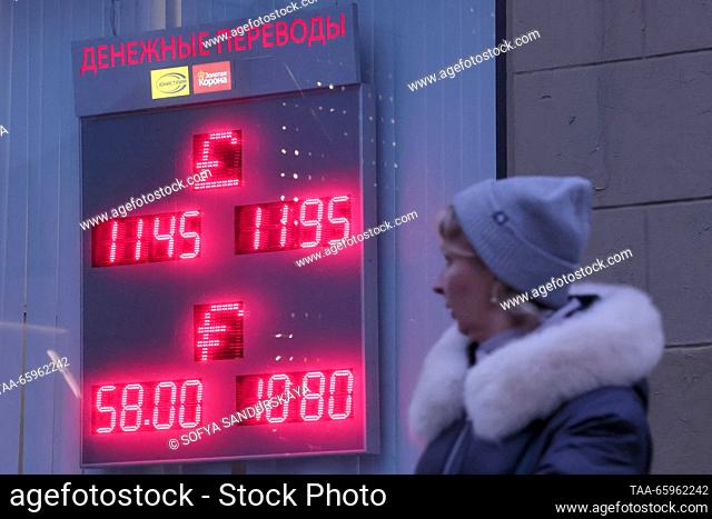 RUSSIA, MOSCOW - DECEMBER 21, 2023: A woman walks past an information board showing foreign currency exchange rates. The Bank of Russia has set the US dollar...