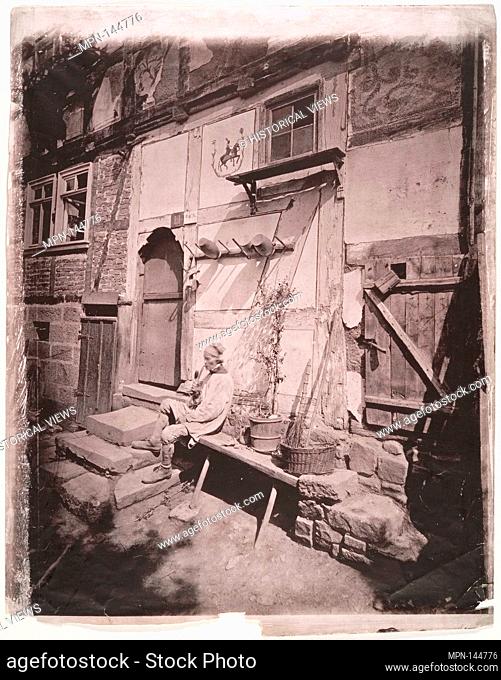 [Man Smoking Pipe Outside His Home on Village Street]. Artist: Unknown (German); Date: 1880s; Medium: Collotype; Dimensions: 37.2 x 29.1 cm