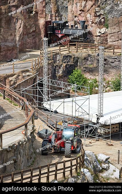 12 July 2021, Schleswig-Holstein, Bad Segeberg: A telescopic loader moves during the construction of a concert stage in the Karl May circuit at Kalkberg