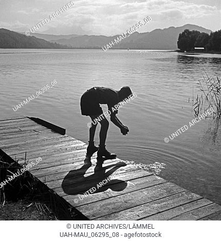 Ein Hitlerjunge beim Händewaschen in einem See nahe vom Hitlerjugend Lager, Österreich 1930er Jahre. A Hitler youth washing his hands on a boardwalk at a lake...