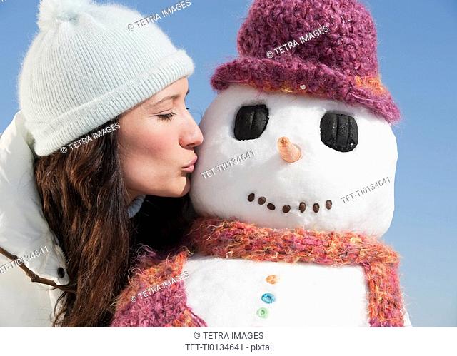 Woman kissing snowman