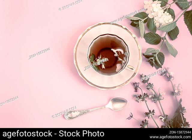 A Cup of herbal tea with sage flowers and mint leaves has a calming effect. Top view, copy space