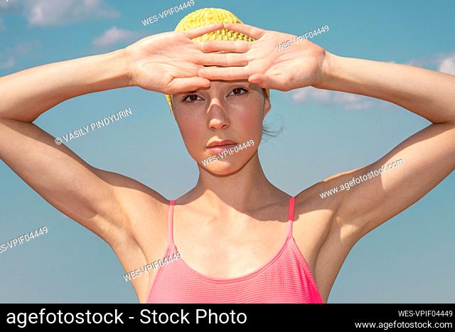 Woman staring with hands raised during sunny day