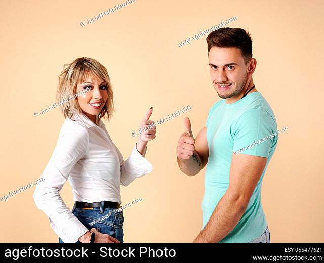 Two young people, man and woman, pose with positive and winning aptitude