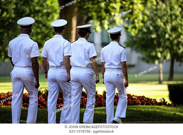 Cadets in sevice whites march on the campus of the US Naval Academy, Annapolis, Maryland, USA