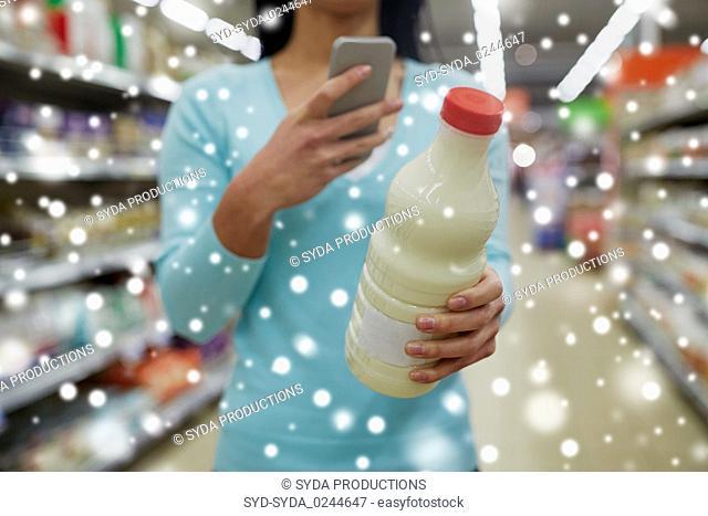customer with smartphone and milk at supermarket