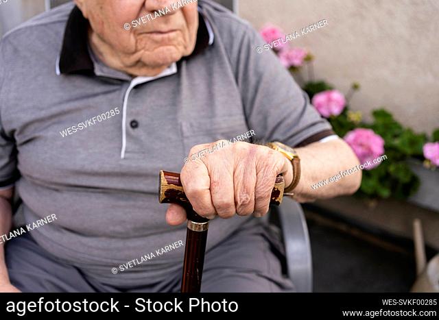 Hand of senior man holding cane