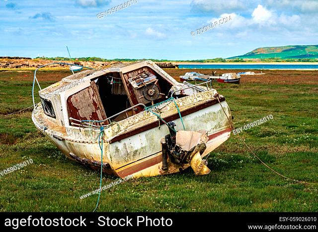 The wreck of a boat in the grass, seen in Askam-in-Furness, Cumbria, England, UK