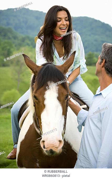 woman sitting on a horse with a man beside her