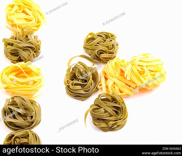 Tagliatelle paglia e fieno homemade tipycal italian pasta close-up on the white background