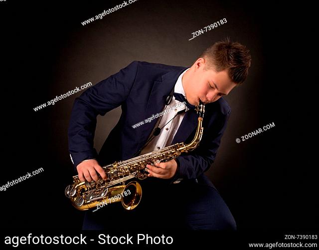 Top saxophonist playing sax during a live jazz session. Man in navy blue suit performing on festival