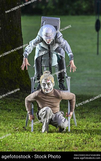 01 August 2023, Brandenburg, Netzeband: Actors with masks play as Mr. Fusi (below) and Gray Lord during a rehearsal of the play ""Momo"" at the Theater Summer...