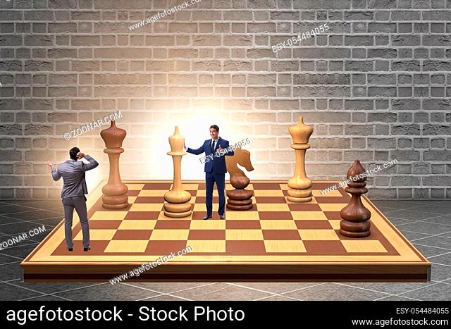The businessman in large chess board in strategy concept