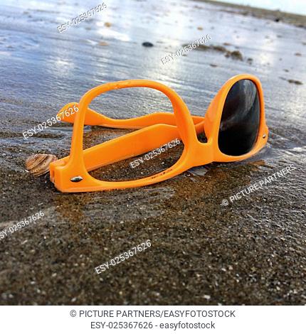 Dumped broken sunglasses near the sea on the beach