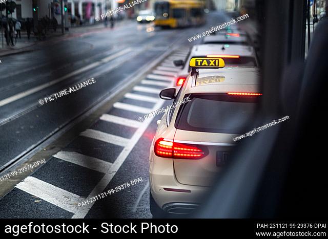 21 November 2023, Saxony, Dresden: A cab stands on a road in traffic. Photo: Robert Michael/dpa. - Dresden/Saxony/Germany