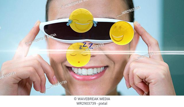 Happy woman looking at various emojis on VR glasses