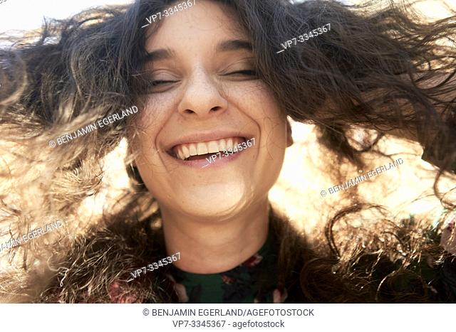 happy unvarnished woman smiling in sunlight