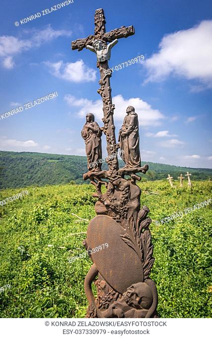 Old rusty cross on a abandoned cemetery near ruined castle in former Chervonohorod village in Zalischyky region, Ternopil Province, Ukraine
