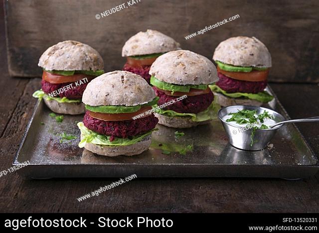 Vegan mini burgers with beetroot patty, lettuce, tomato and avocado