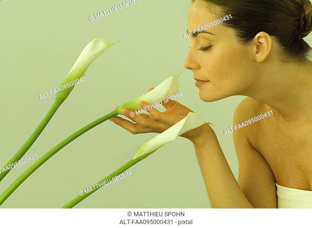 Young woman smelling calla lilies