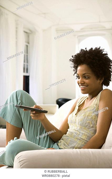 Young woman holding a remote control