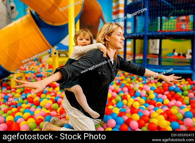 Children plays with mother in the entertainment center. Mom and her daughter leisures on holidays, childhood happiness, happy kids on playground