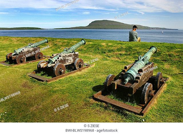 three old cannons and a man looking at the sea, Denmark, Faroe Islands, Streymoy, Torshavn