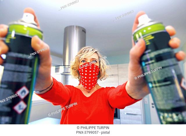 Young woman at home using air spray
