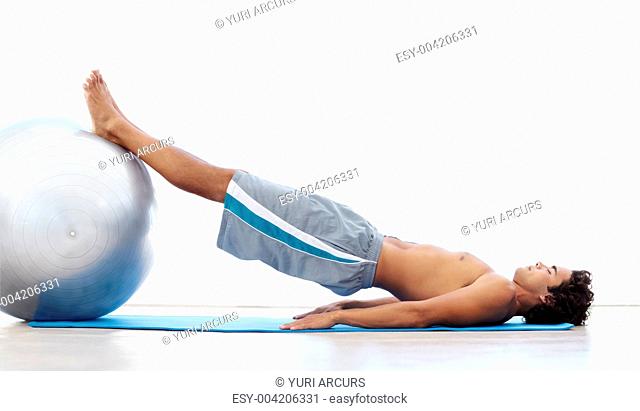 A young man using a swissball to strengthen his core muscles