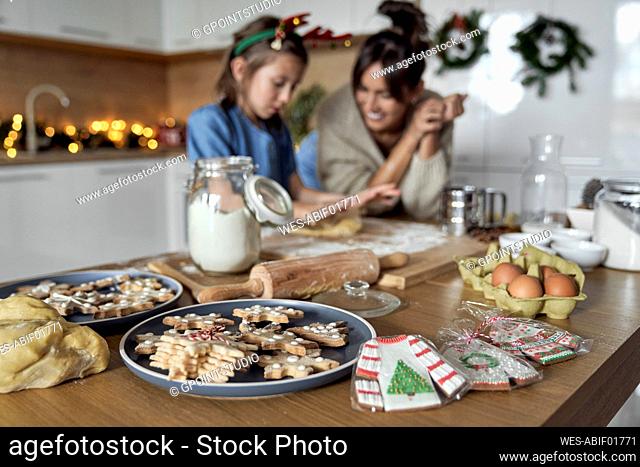 Cookie on table with mother and daughter in background
