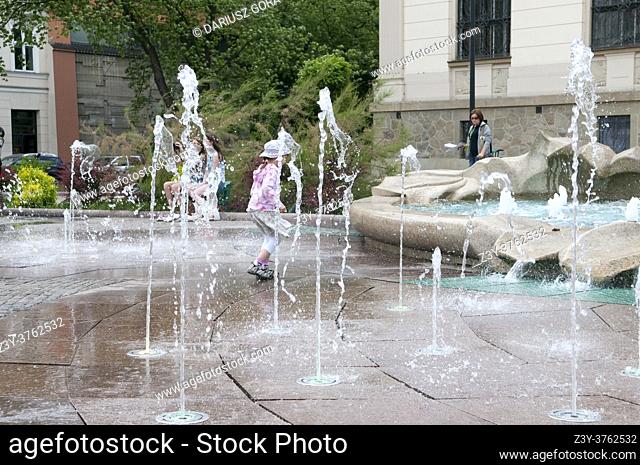 Child playing by the fountain, Krakow, Poland