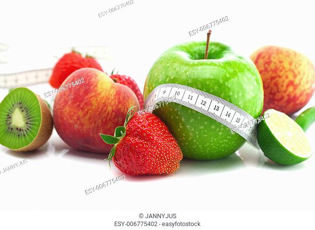 big juicy red ripe strawberries, apple, lime, peach, kiwi and measure tape isolated on white
