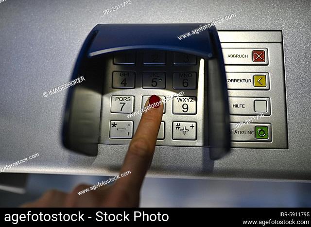 Woman typing in secret code at the cash machine of a savings bank, Waiblingen, Baden-Württemberg, Germany, Europe