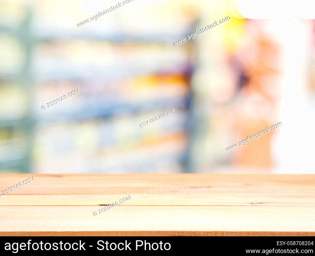 Wooden board empty table in front of blurred background. Perspective light wood over blur in supermarket - can be used for display or montage your products