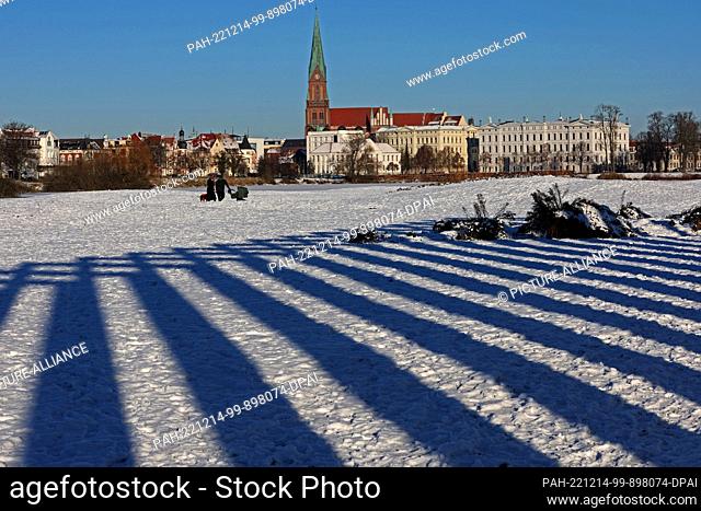 14 December 2022, Mecklenburg-Western Pomerania, Schwerin: The stelae of a portico cast dark blue shadows in the snow. Winter has Germany firmly in its grip...