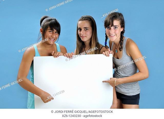 Three girls holding a blank sign, with blue backgroud