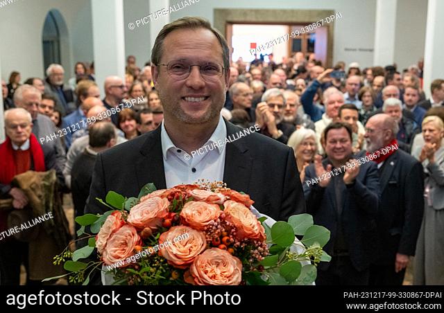 17 December 2023, Baden-Württemberg, Ulm: Martin Ansbacher (SPD) stands in the town hall with a bouquet of flowers after his victory in the run-off election for...