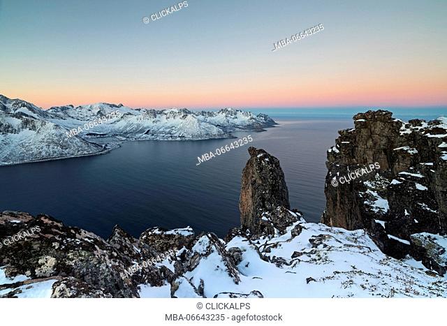 View of the Mefjorden framed by frozen sea and pink sky at sunrise from the top of Mount Hesten Senja Tromsø Norway Europe