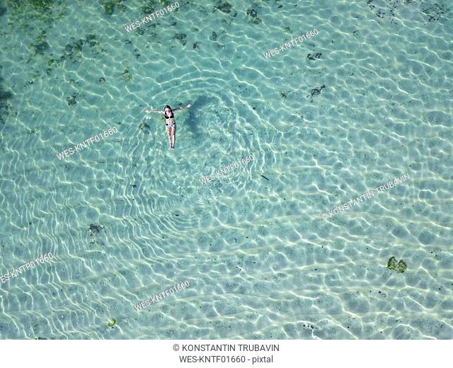 Indonesia, Bali, Melasti, Aerial view of Karma Kandara beach, woman floating on water