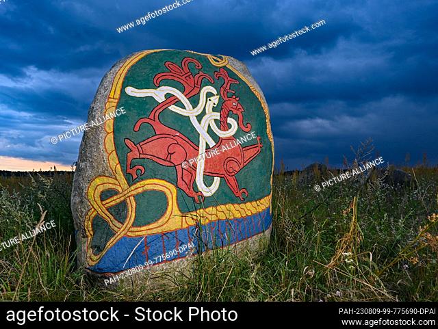 08 August 2023, Brandenburg, Henzendorf: Figures carved and painted in stone can be seen on an erratic boulder in the grounds of the Henzendorf erratic boulder...