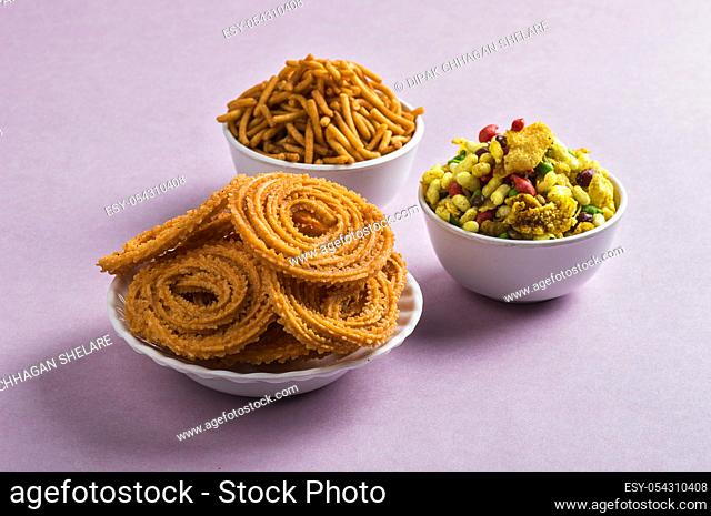 Indian Snack : Chakli, chakali or Murukku and Besan (Gram flour) Sev and chivada or chiwada on pink background. Diwali Food