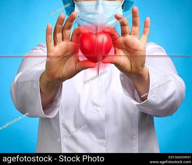 doctor in a white medical coat holding a red heart. Cardiovascular disease concept, early diagnosis. Blue background